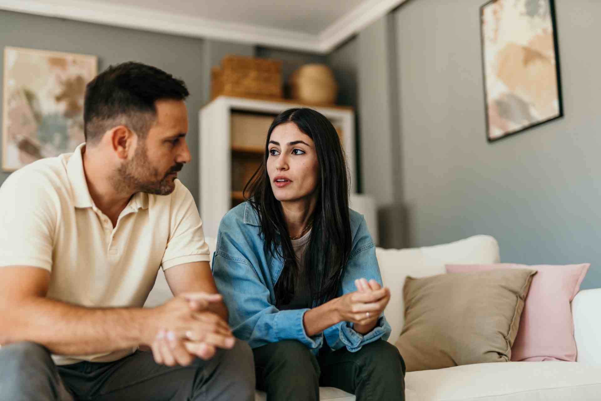 Couple having a serious conversation at home about emotional well-being and mental health support.