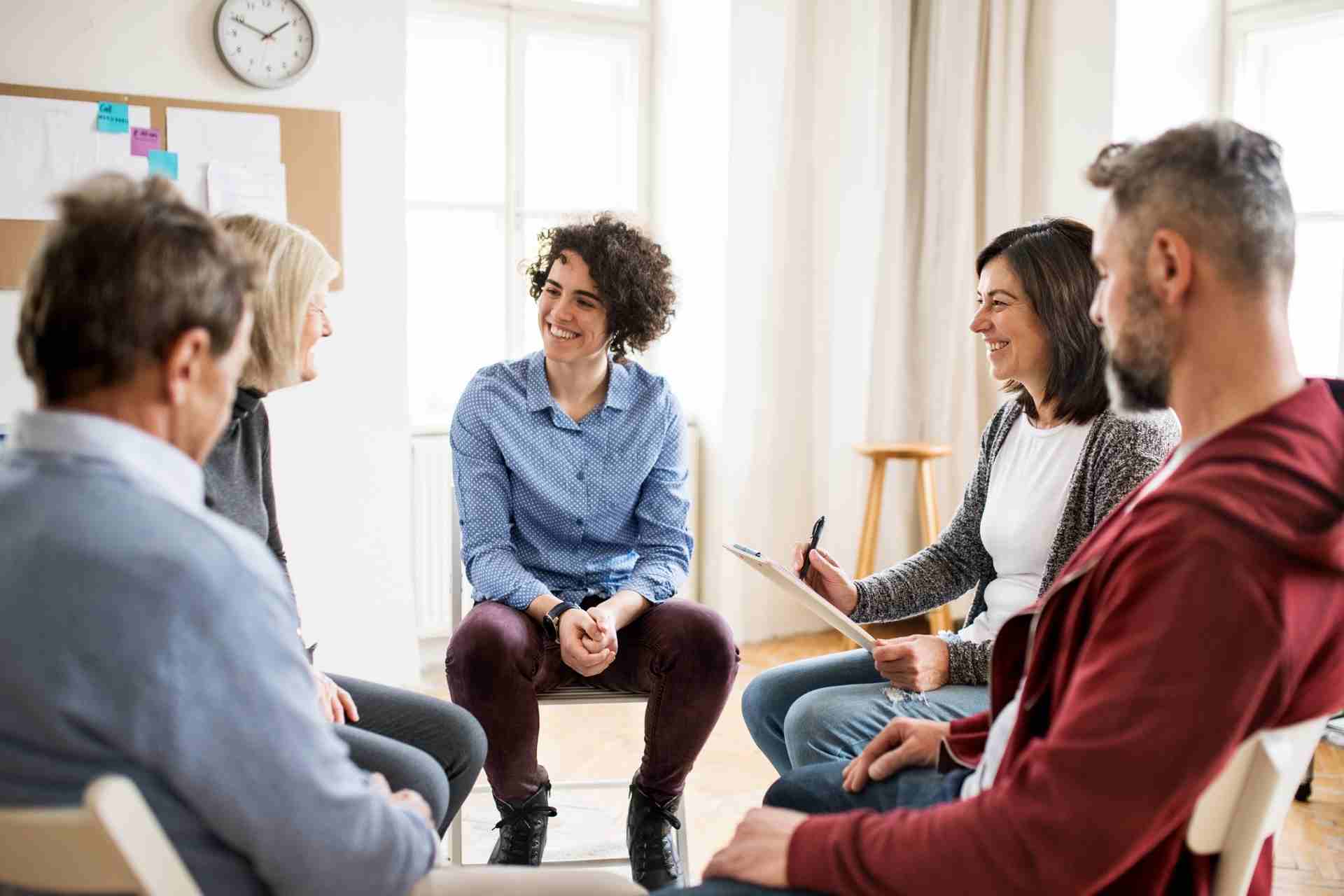 College students participating in a supportive group therapy session led by a mental health counselor in New Jersey.